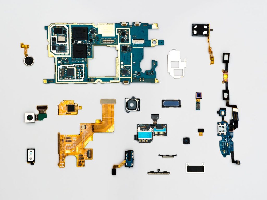 blue-and-yellow-phone-modules-1476321 Exploded view of smartphone components showcasing intricate technological design.